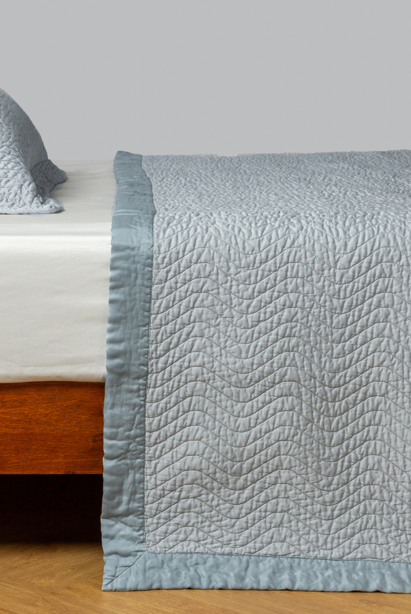 Cloud: quilted cotton sateen coverlet with matching sham on a winter white fitted sheet - side view. 