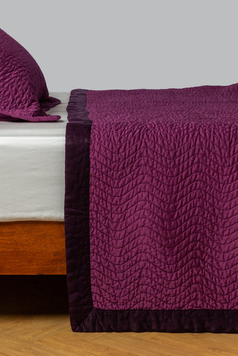 Fig: quilted cotton sateen coverlet with matching sham on a winter white fitted sheet - side view. 