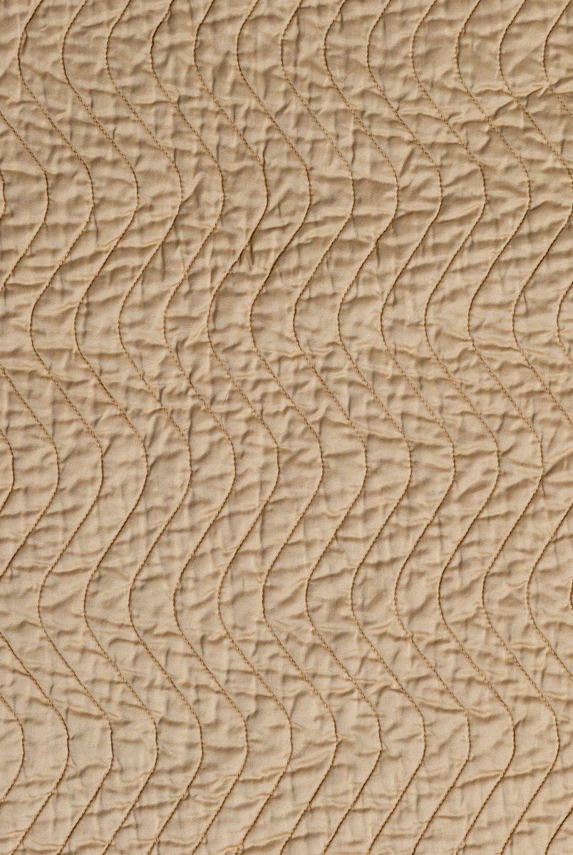 Honeycomb: A close up of quilted cotton sateen fabric in honeycomb, a warm golden tone.
