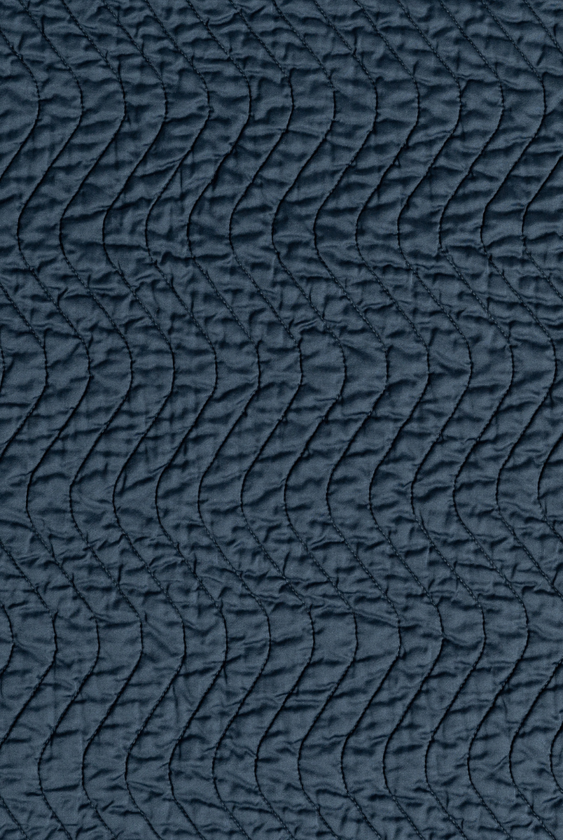 Midnight: A close up of quilted cotton sateen fabric in midnight, a rich indigo tone.