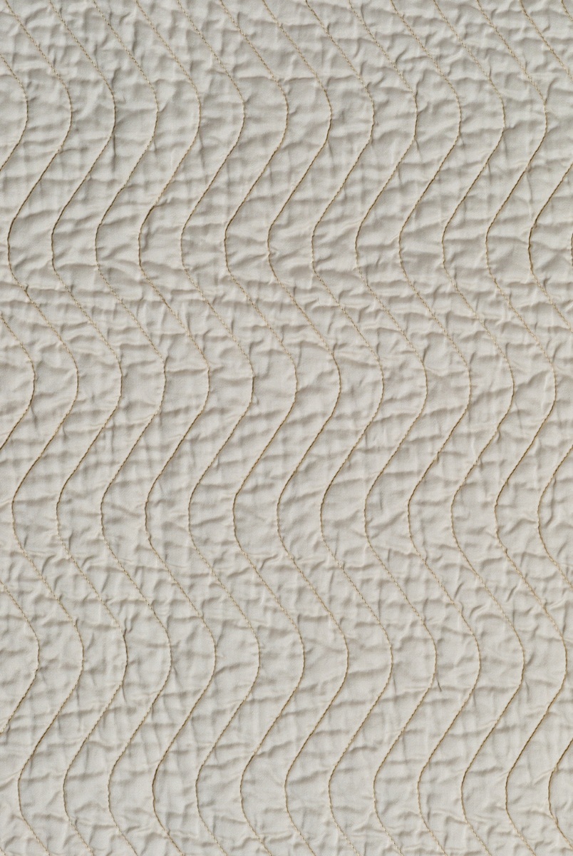 Parchment: A close up of quilted cotton sateen fabric in parchment, a warm, antiqued cream.