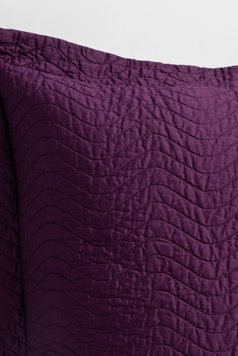 Fig: close up of the corner of a quilted cotton sateen pillow sham - shot against a white background. 