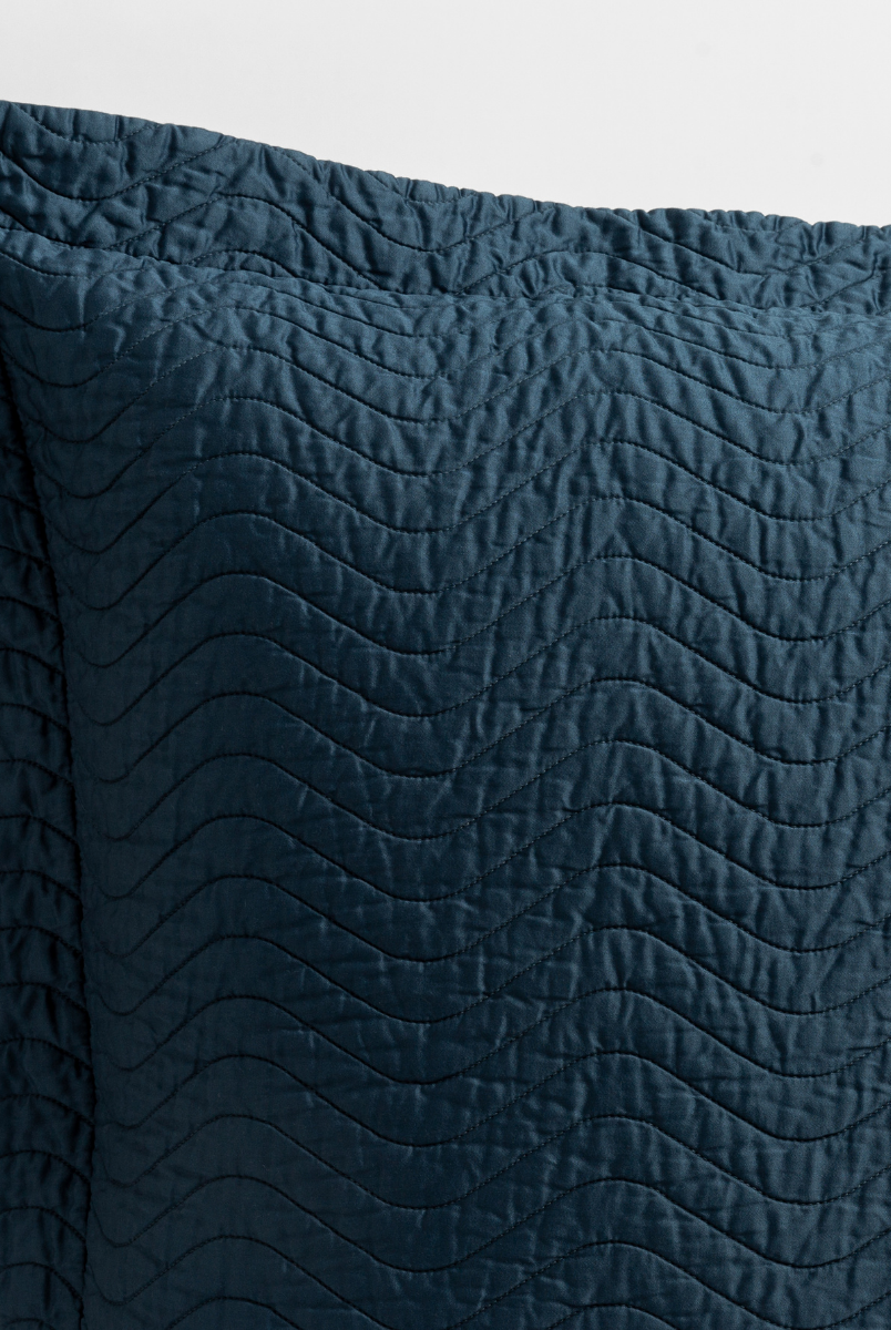 Midnight: close up of the corner of a quilted cotton sateen pillow sham - shot against a white background. 