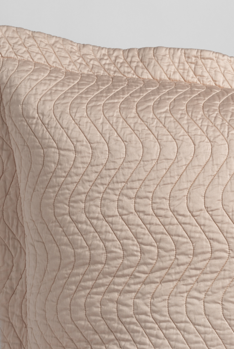 Pearl: close up of the corner of a quilted cotton sateen pillow sham - shot against a white background. 